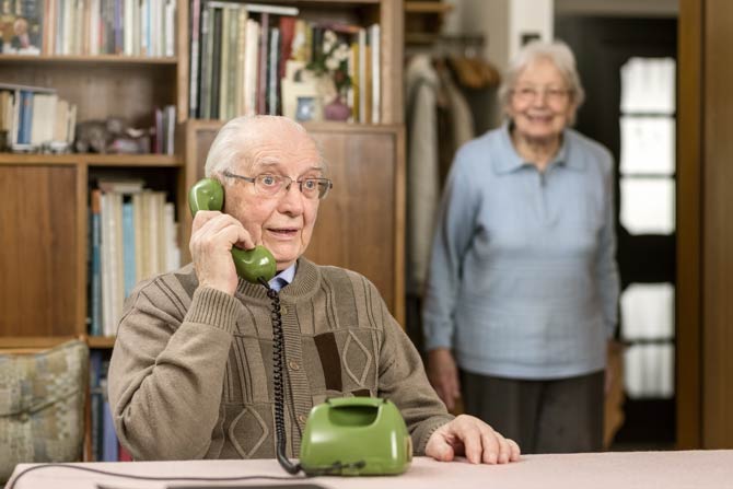 Älterer Herr am Festnetztelefon